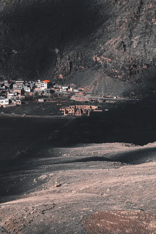 a village is nestled behind a rocky hill