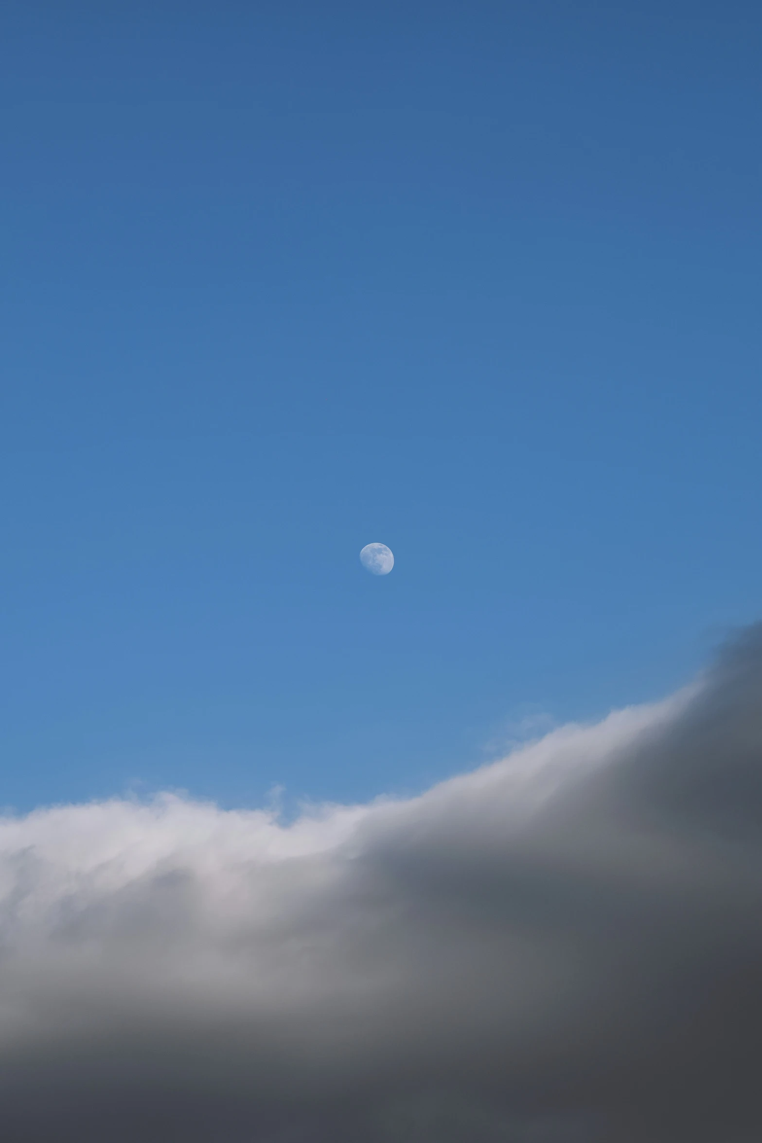 the crescent is shining through a cloud in a sky