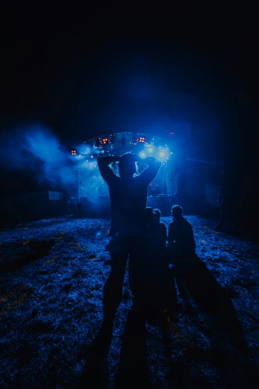 people stand in front of a stage at night