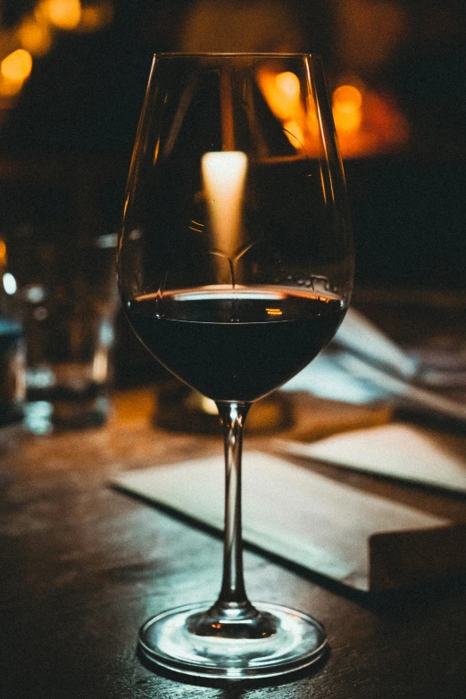 a dark and empty wine glass sits on the table