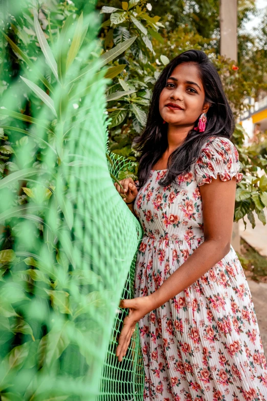 a woman standing in a park behind a fence