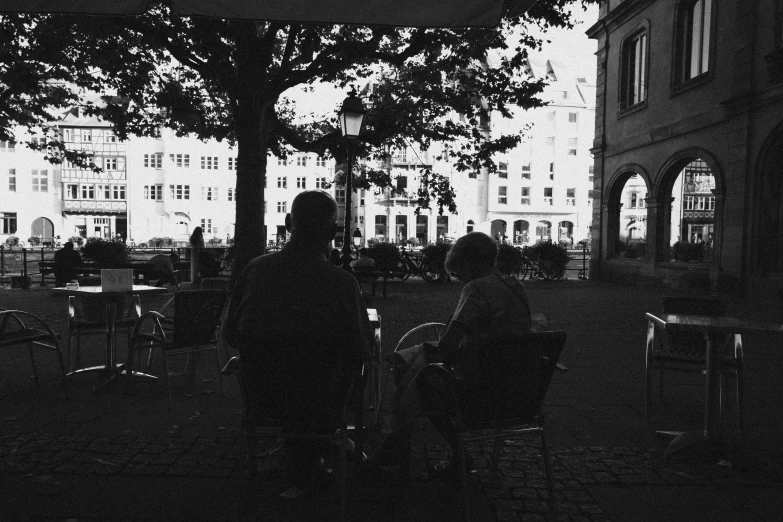 two people sitting at a table on a large courtyard