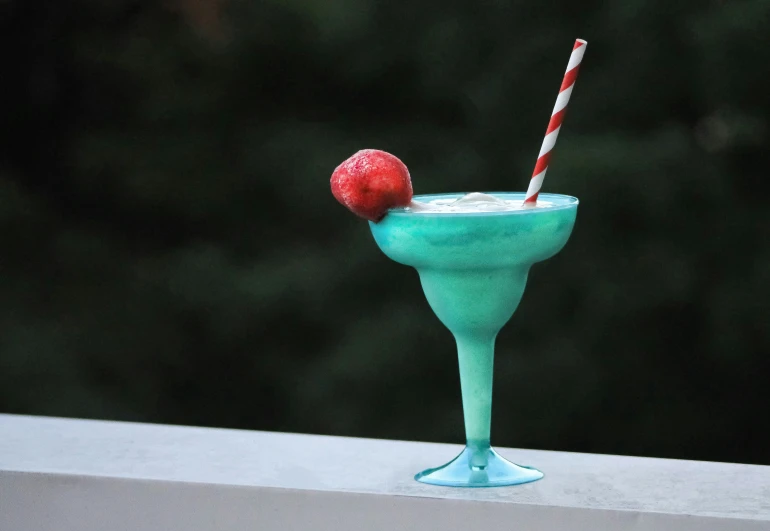 there is a green martini with a cherry on top