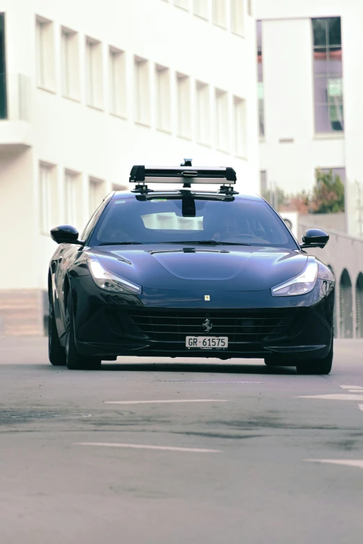 a small black sports car going down the street