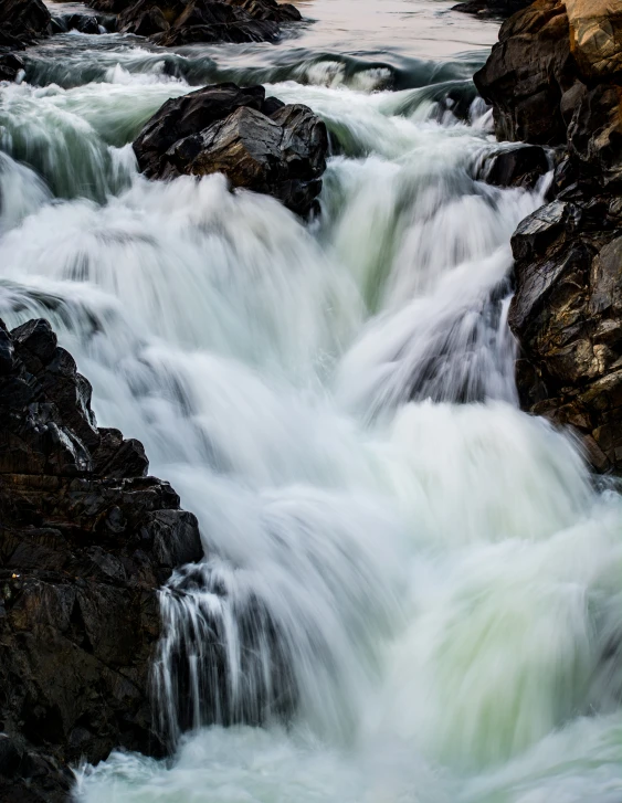 several rocks are sitting in front of a stream