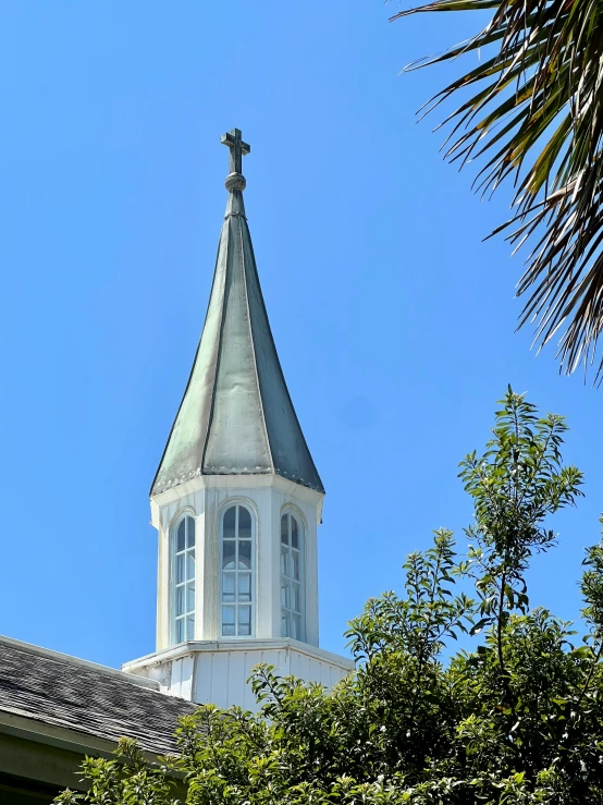 the top of a building with a tall tower with a cross on top