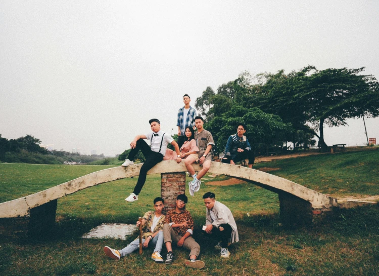 a group of people are sitting on a bridge