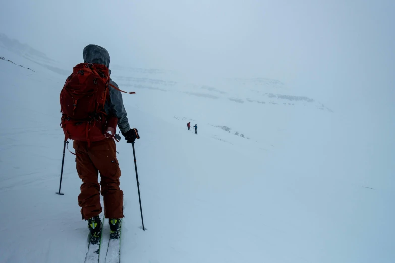 a man that is walking in the snow with skis