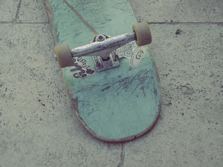 a skateboard laying on concrete with no wheels