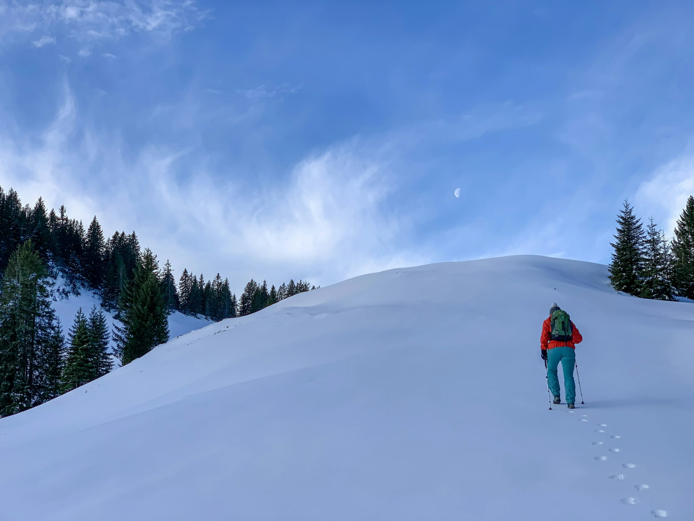 a person in the snow on a snowboard going down a hill