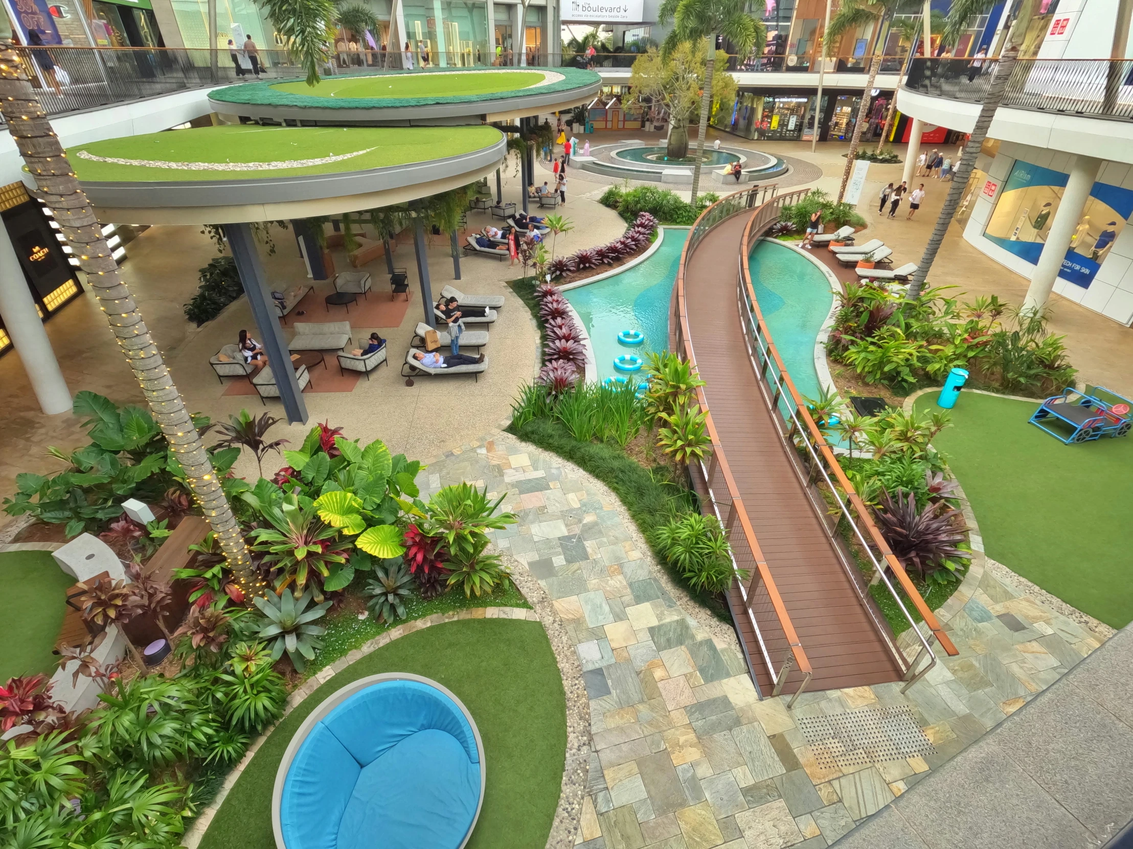 a large atrium of a resort with a pool and other pools