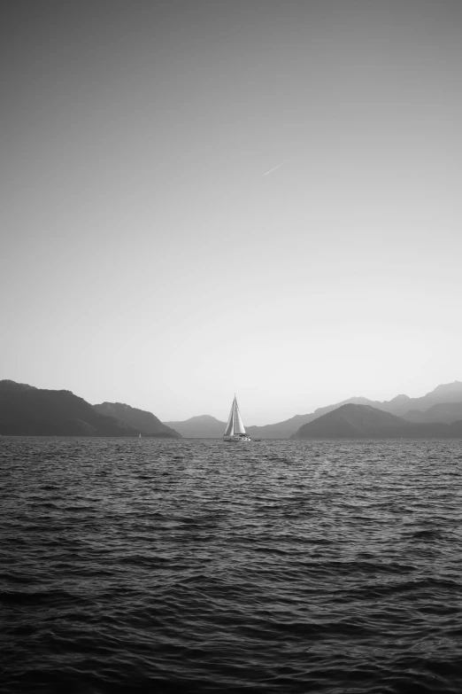 a sailboat traveling down the ocean under a clear sky