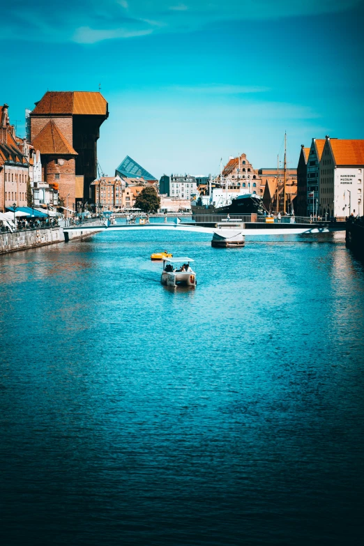 small boats are traveling along the waterway of a european city