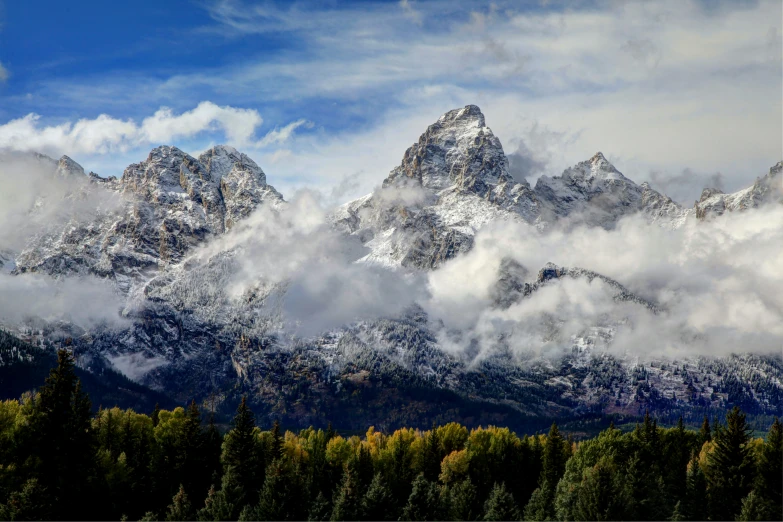 a mountain range is pictured against some cloudy skies