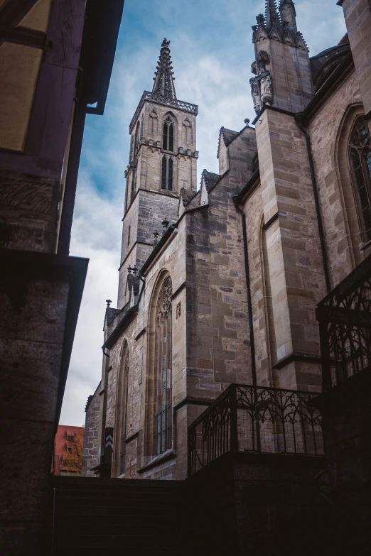 an old gothic church with a steeple against a blue sky