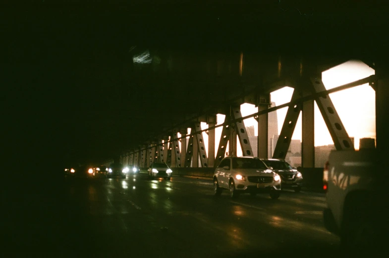 a car driving on a long bridge in the night