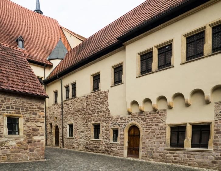 two brown brick buildings and cobblestone stone streets