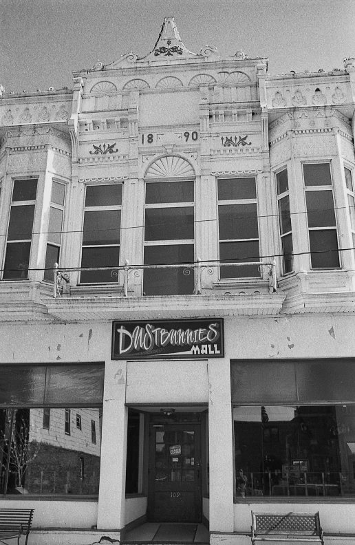 the front entrance to a building with benches outside it