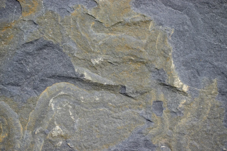 several different gray and brown rocks with yellow patches