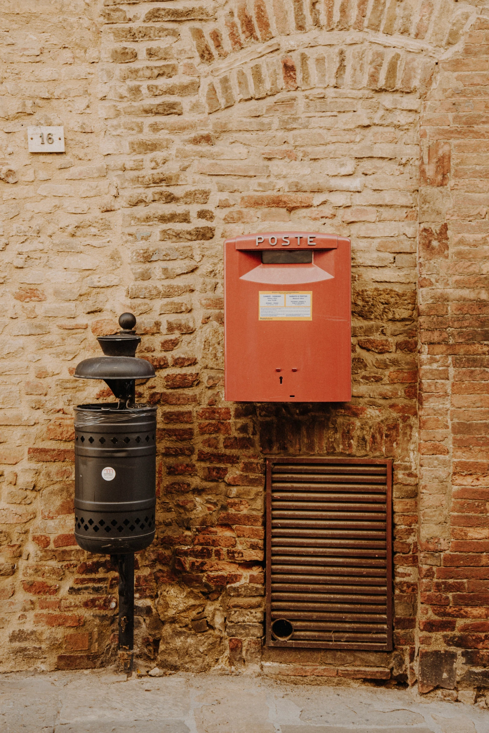 a mail box next to an open door on the side of a brick wall