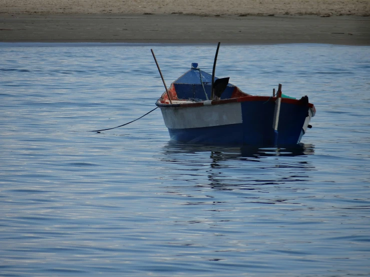 a blue and white boat sits in the water