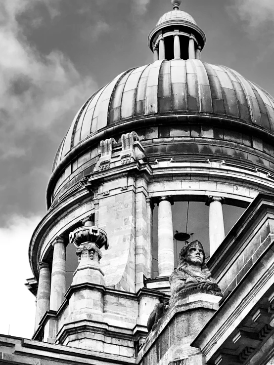 an old stone building has a cupola and two sculptures on the top