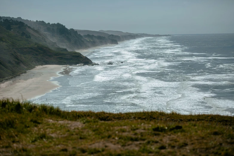 a beach in the distance with an ocean cliff