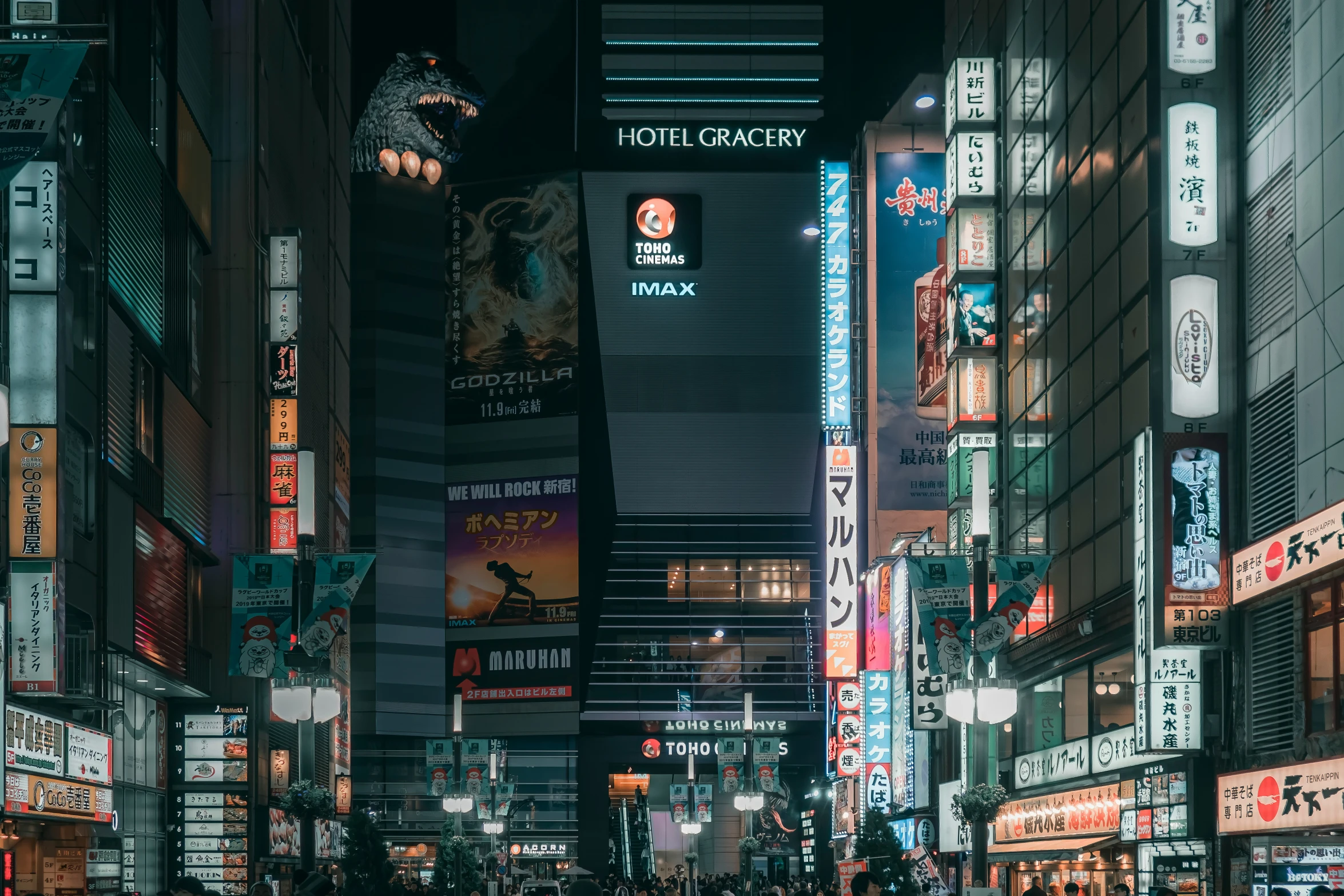 people crossing the street in a busy city at night