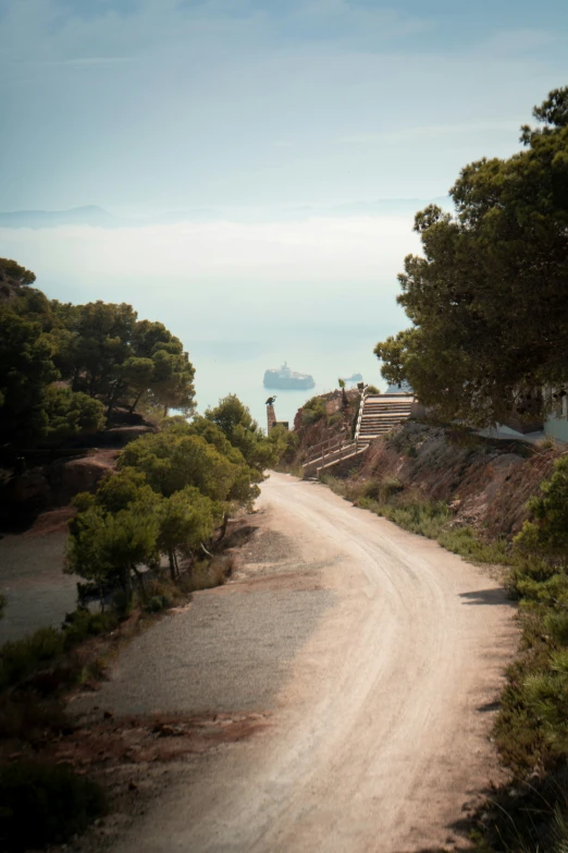 there is a road that runs to a cliff next to trees