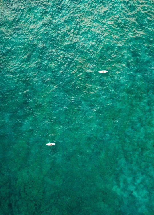 three boats floating in blue water next to each other