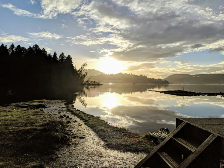 an empty beach with trees and water in the background