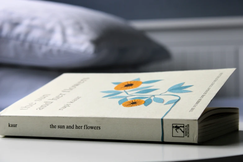 a white book with a flower on it sits on a table