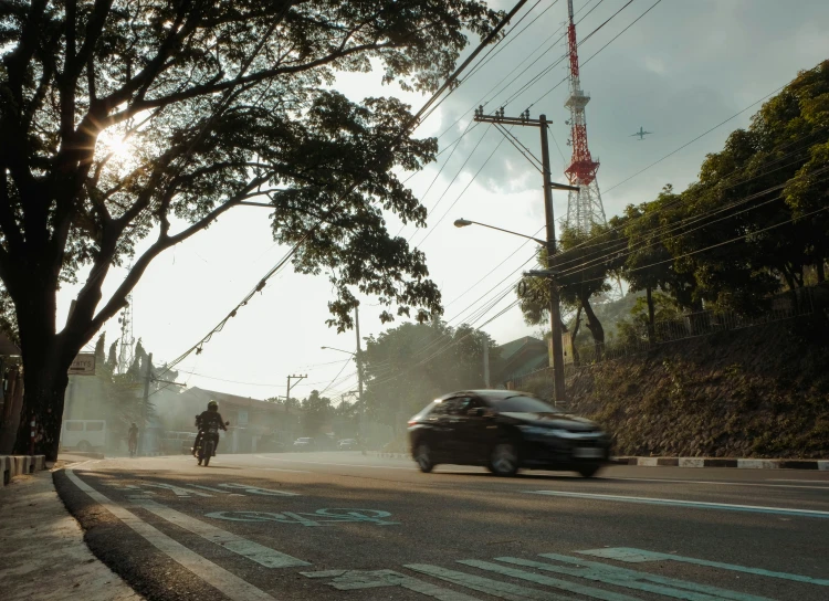 two people on motorcycles passing by a car