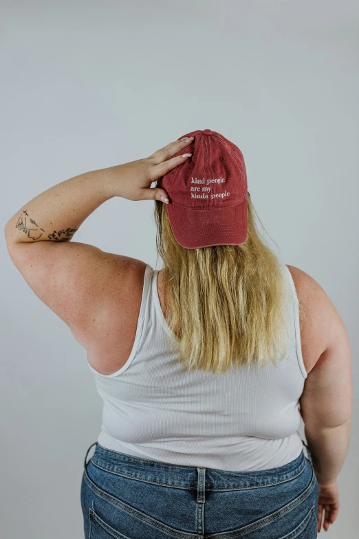 a fat lady with tattoos holding her hat