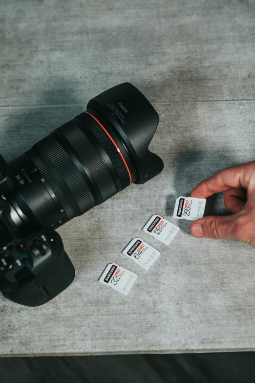 a hand that is holding some cards near a camera