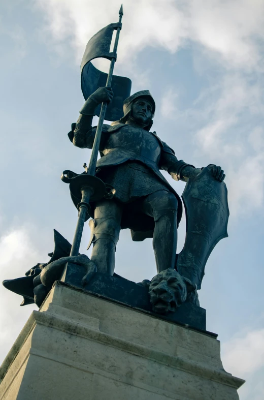 a statue of a man sitting on a horse with a flag