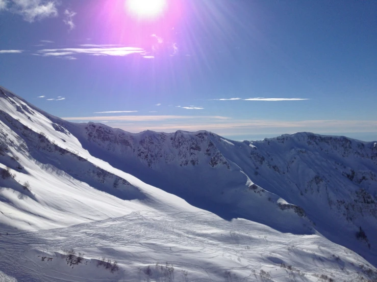 the sun is shining brightly above the snow covered mountains