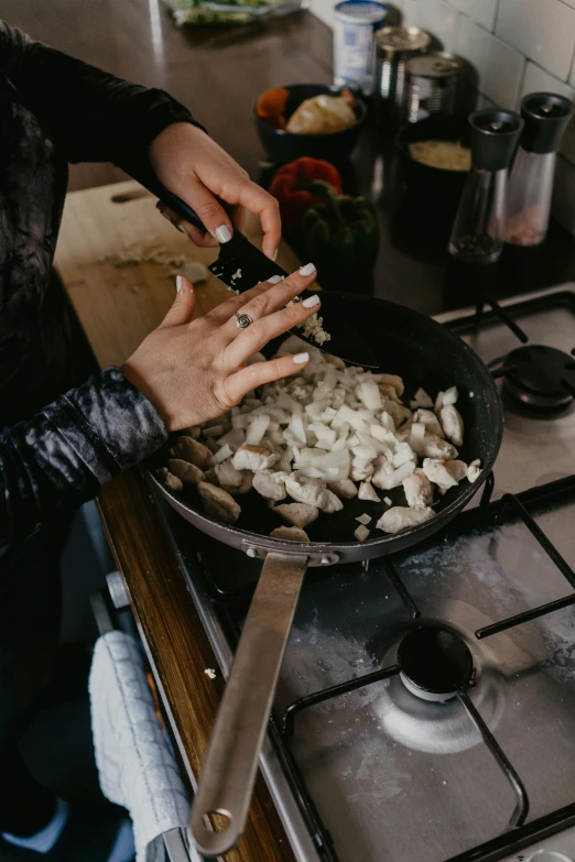woman in black jacket cooking food on stove