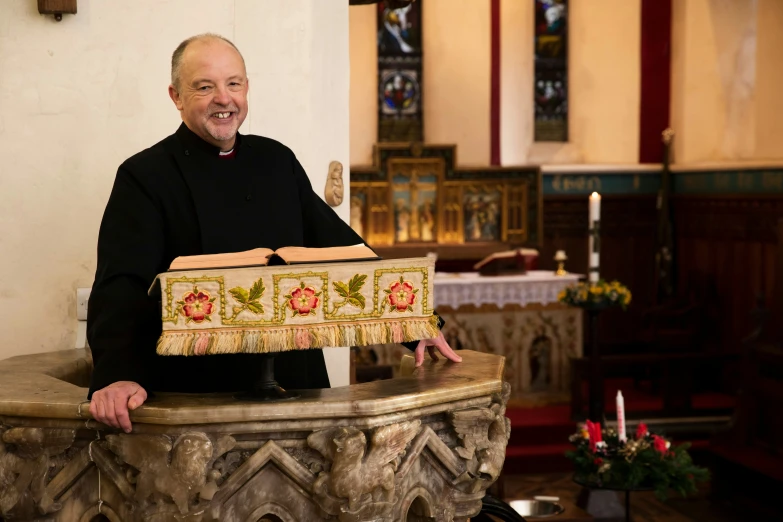 a man standing in a church with an embroidered cross