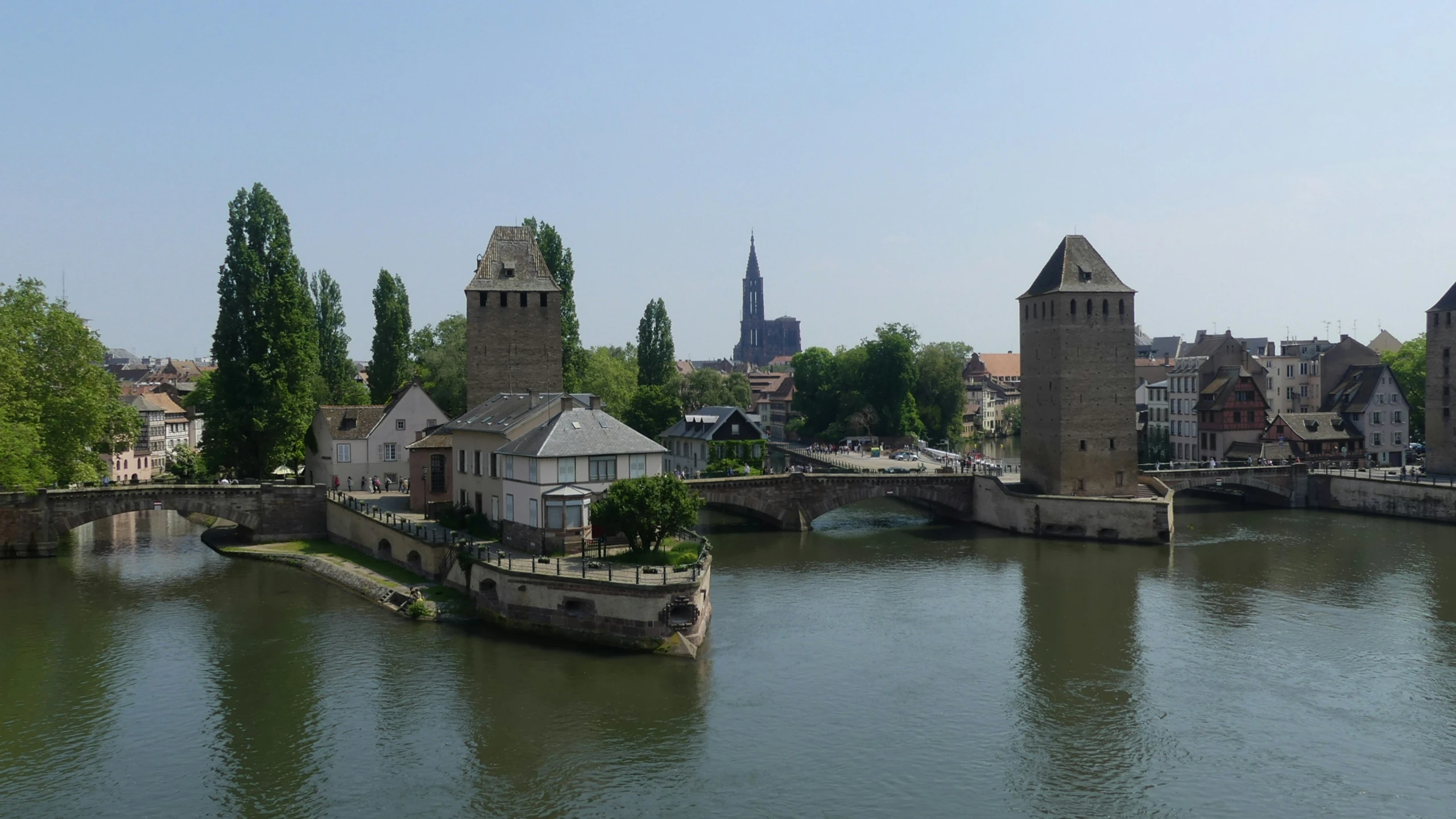 a large building next to the water and with a bridge crossing it