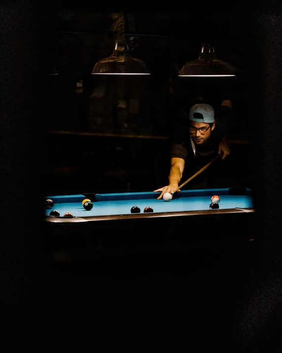 a man is playing pool in an outdoor pool hall