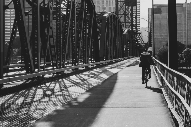 a man riding a bike down a long bridge