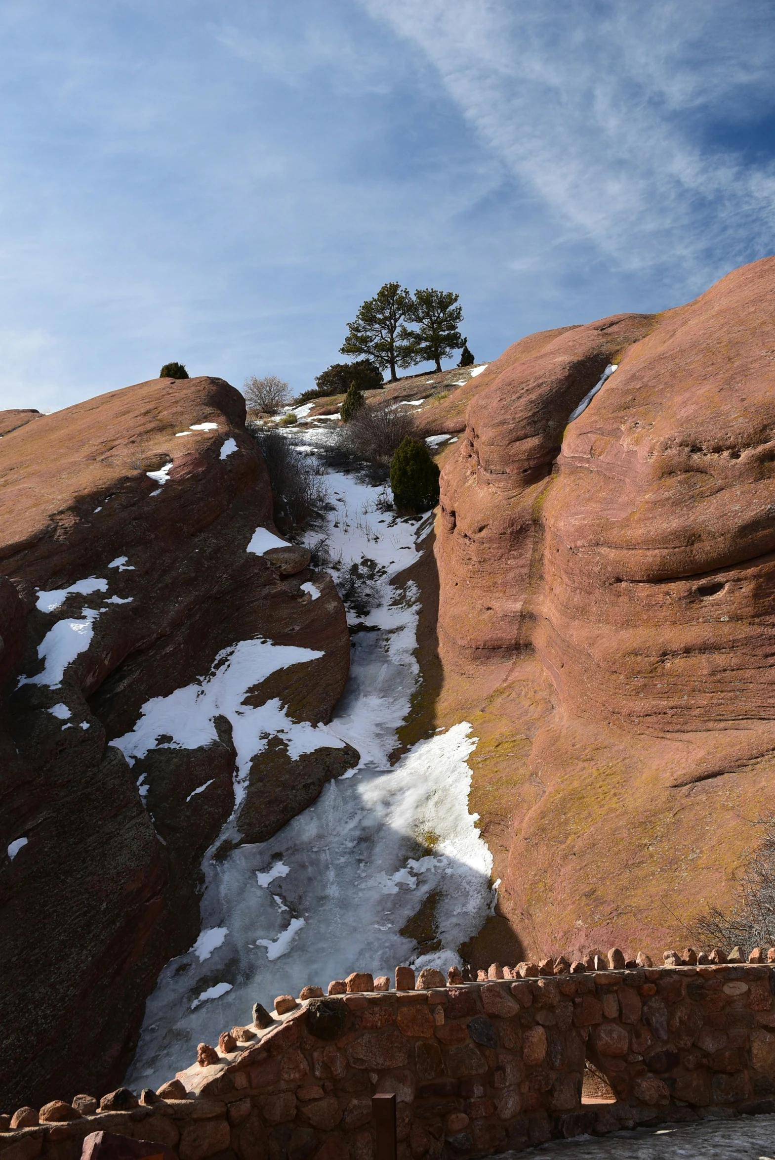 a snow covered mountain side with large rock formation