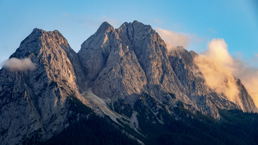 three mountain range covered with snow and clouds