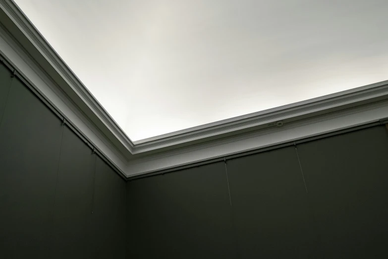 a sky light above a room with some green walls