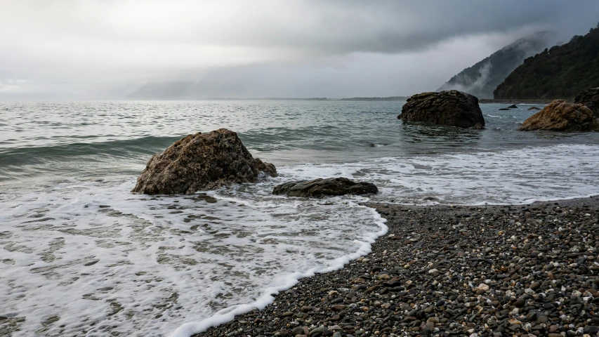 the ocean water is running right into some rocky shore