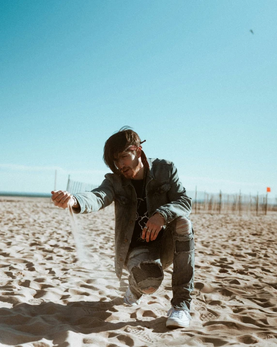 a man in black jacket standing on top of sand