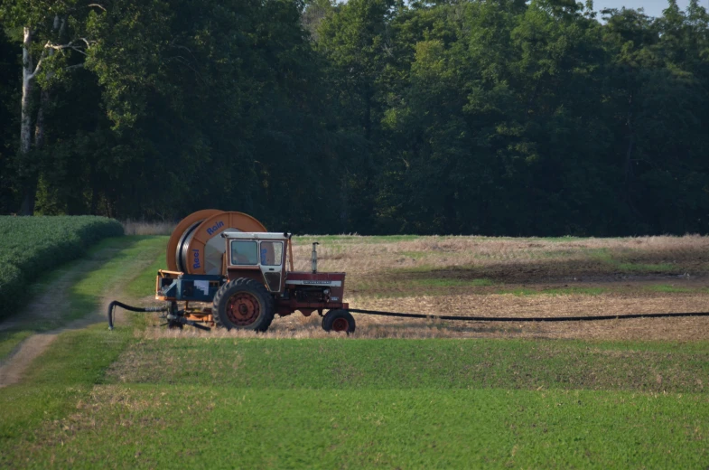 a tractor in a large field spraying water