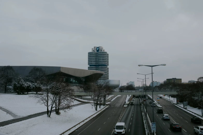 many cars travelling on the road next to the buildings