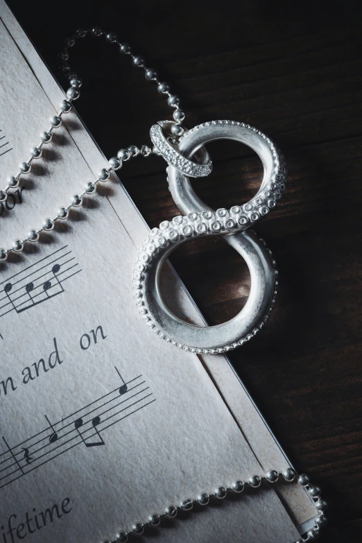 a book that has music on it with a necklace on top